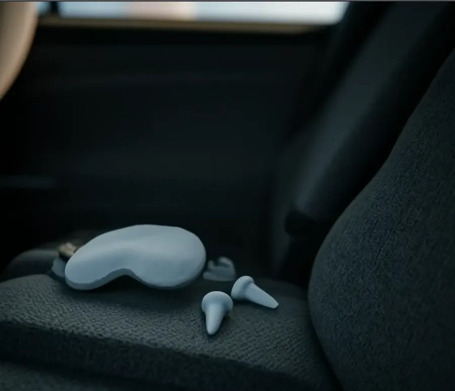 Masque de sommeil et bouchons d’oreille sur un siège de voiture, passager prêt à se reposer